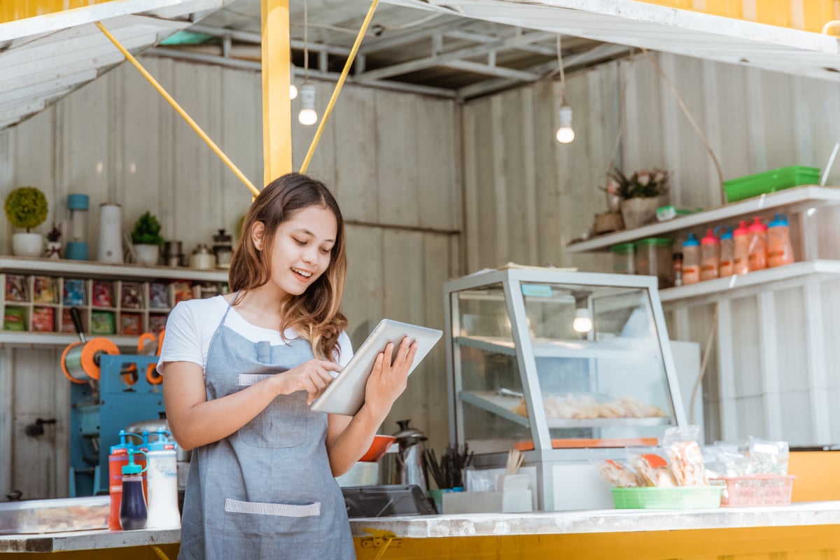 Woman Taking Online Order at Her Small Stall Shop